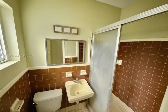 a bathroom with a toilet a sink and mirror