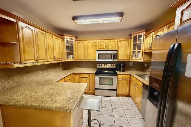 a kitchen with stainless steel appliances granite countertop a sink stove and microwave