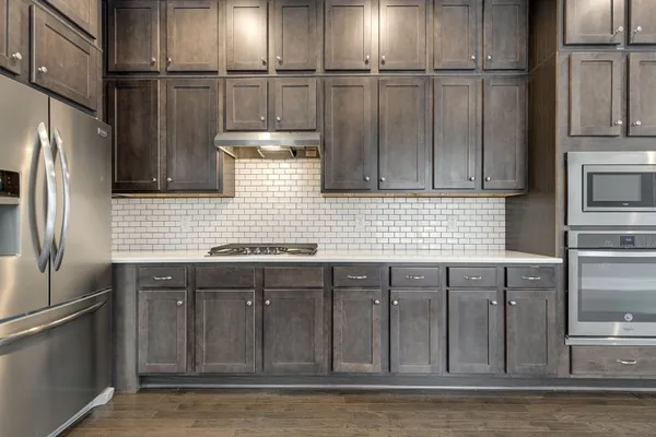 a kitchen with stainless steel appliances granite countertop a refrigerator a stove and a sink