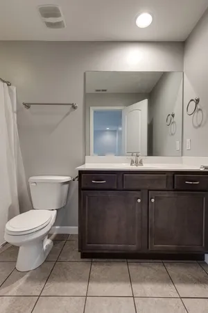 a bathroom with a toilet a sink and mirror