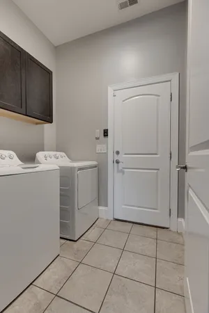 a utility room with cabinets dryer and washer