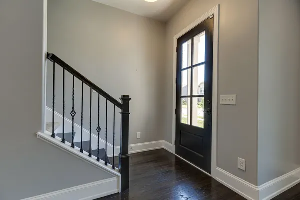 an entryway with wooden floor and stairs