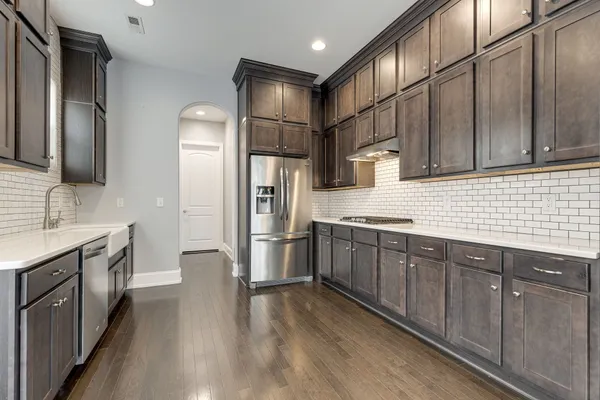 a kitchen with stainless steel appliances granite countertop a refrigerator a sink dishwasher a stove and oven