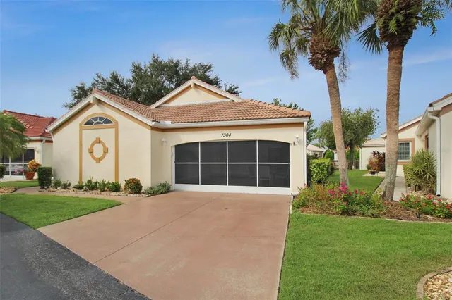 a front view of a house with a garden and trees