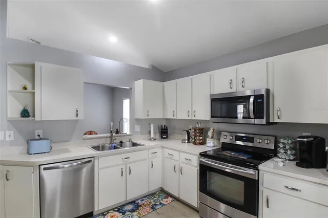 a kitchen with stainless steel appliances granite countertop a sink a stove a microwave and cabinets