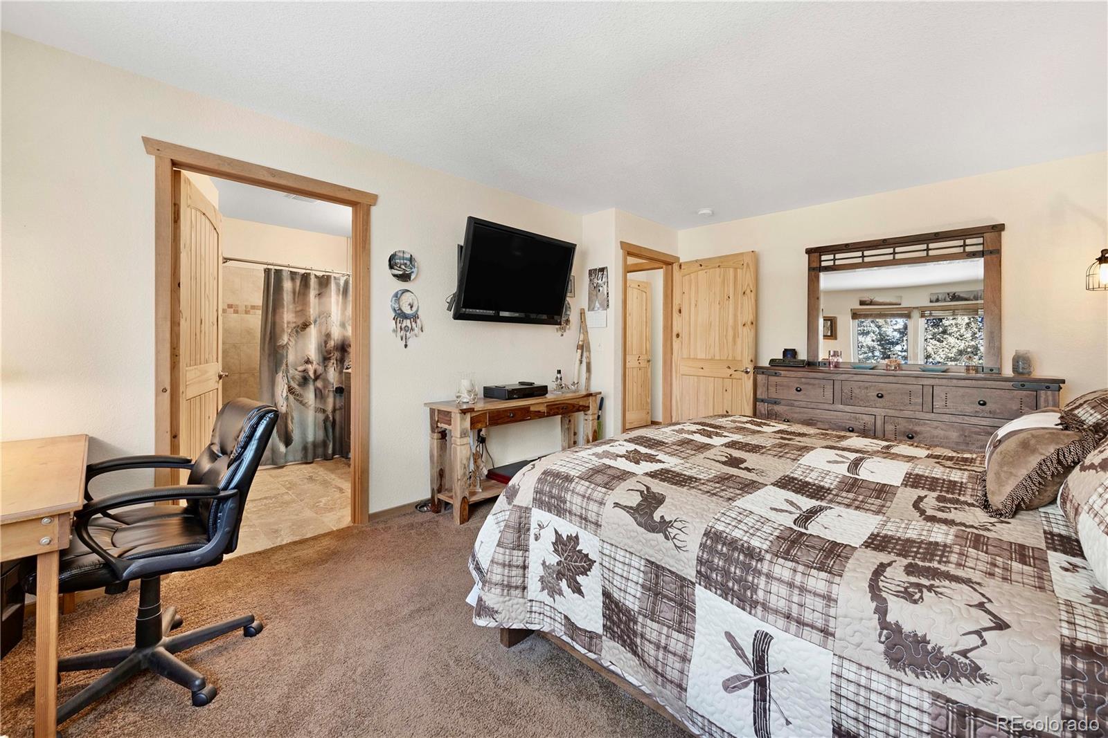 47 Piute Way Como, CO 80432 - Photo 23 of 50 a bedroom with a bed a chair and a flat tv screen on the dresser