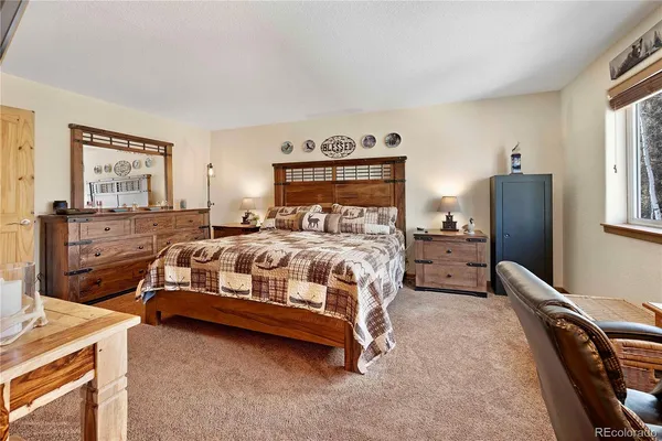 a bedroom with a bed and a flat tv screen on dresser