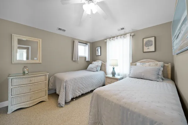 a bedroom with two bed and a window