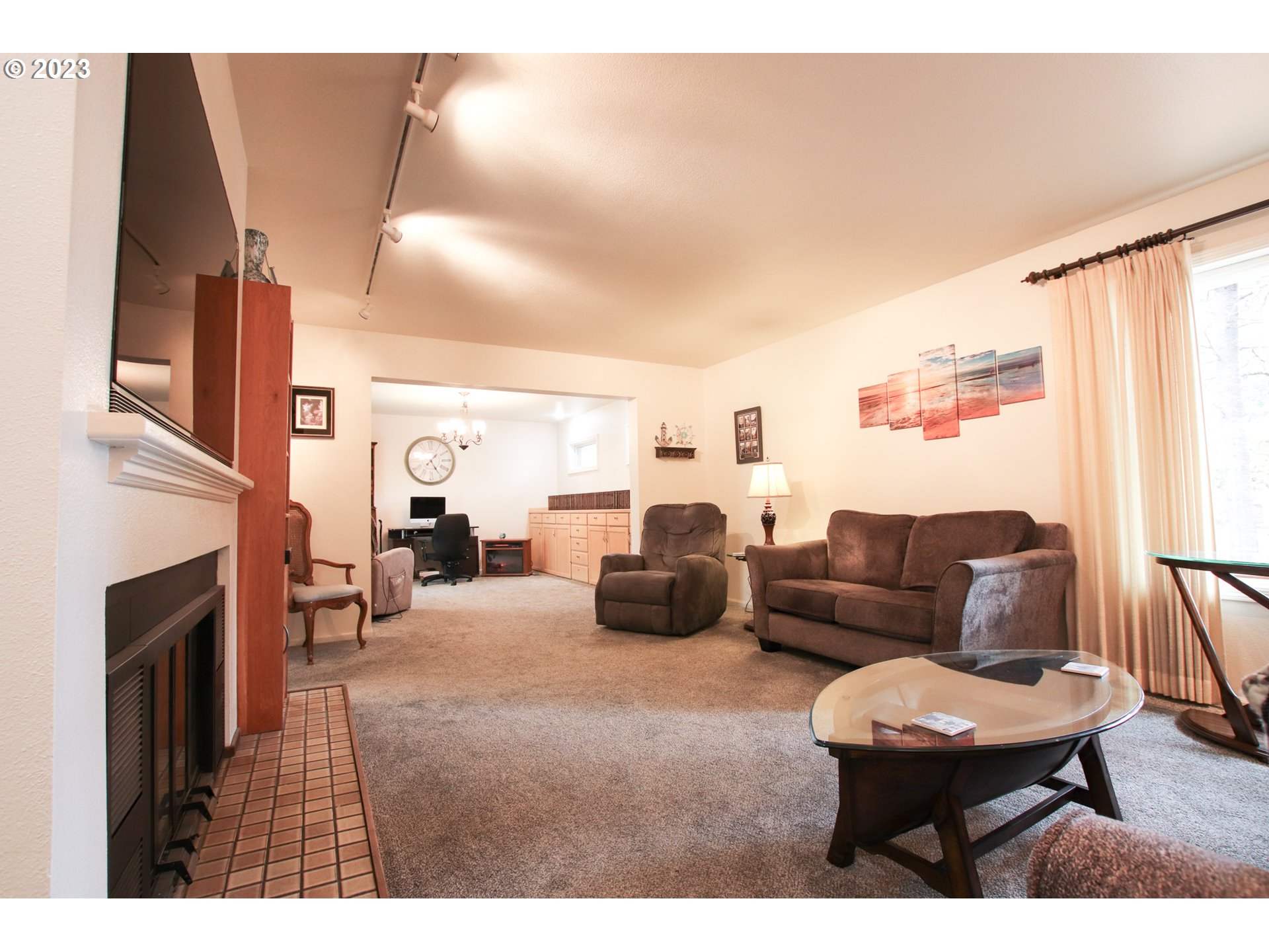 2240 23rd Street Florence, OR 97439 - Photo 13 of 37 a living room with furniture a fireplace and a large window