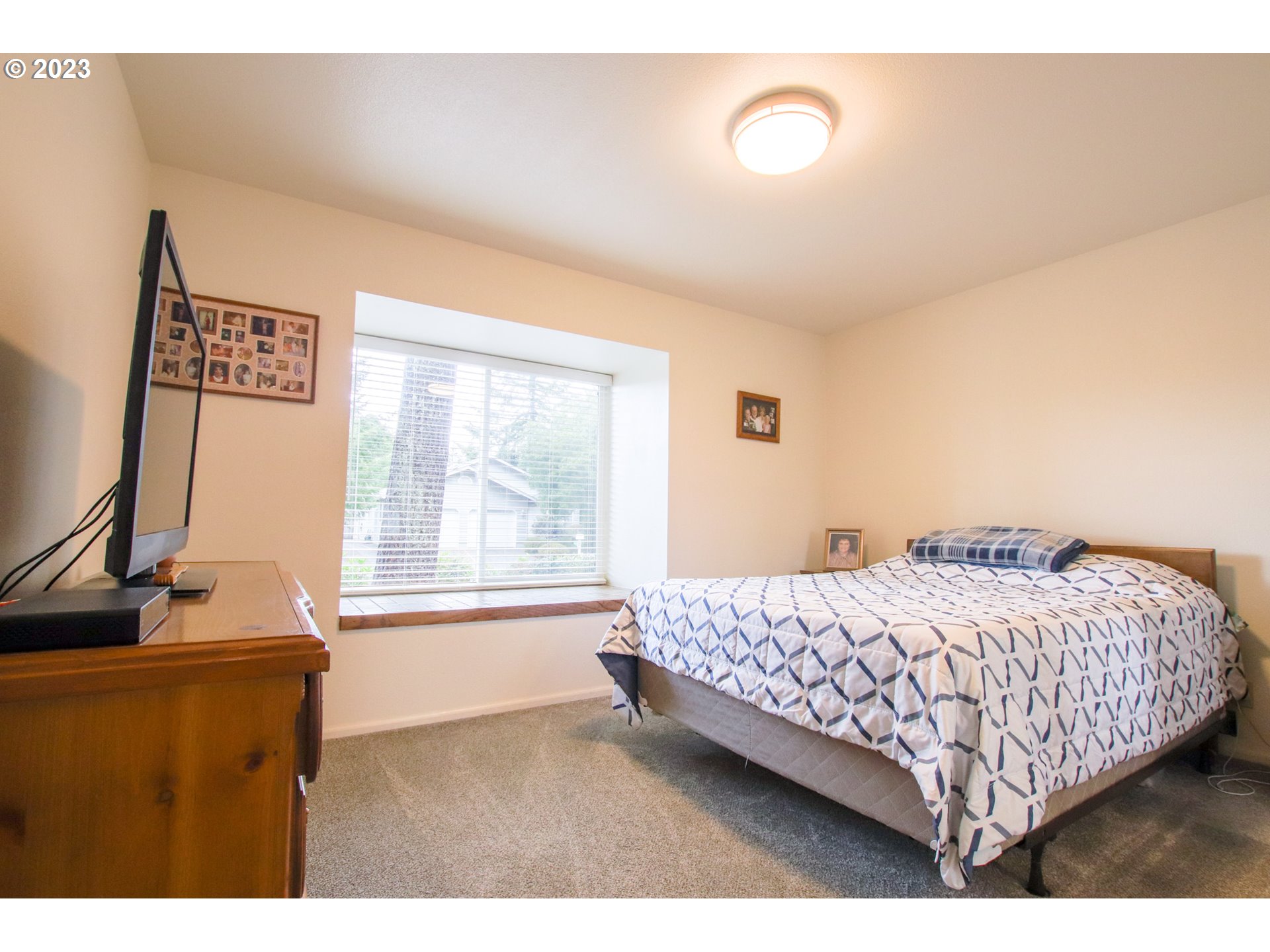 2240 23rd Street Florence, OR 97439 - Photo 32 of 37 a bedroom with a bed and a flat tv screen on the dresser
