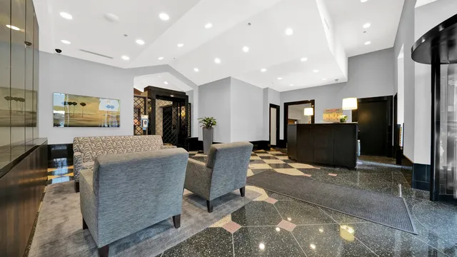 a living room with furniture a flat screen tv and a refrigerator