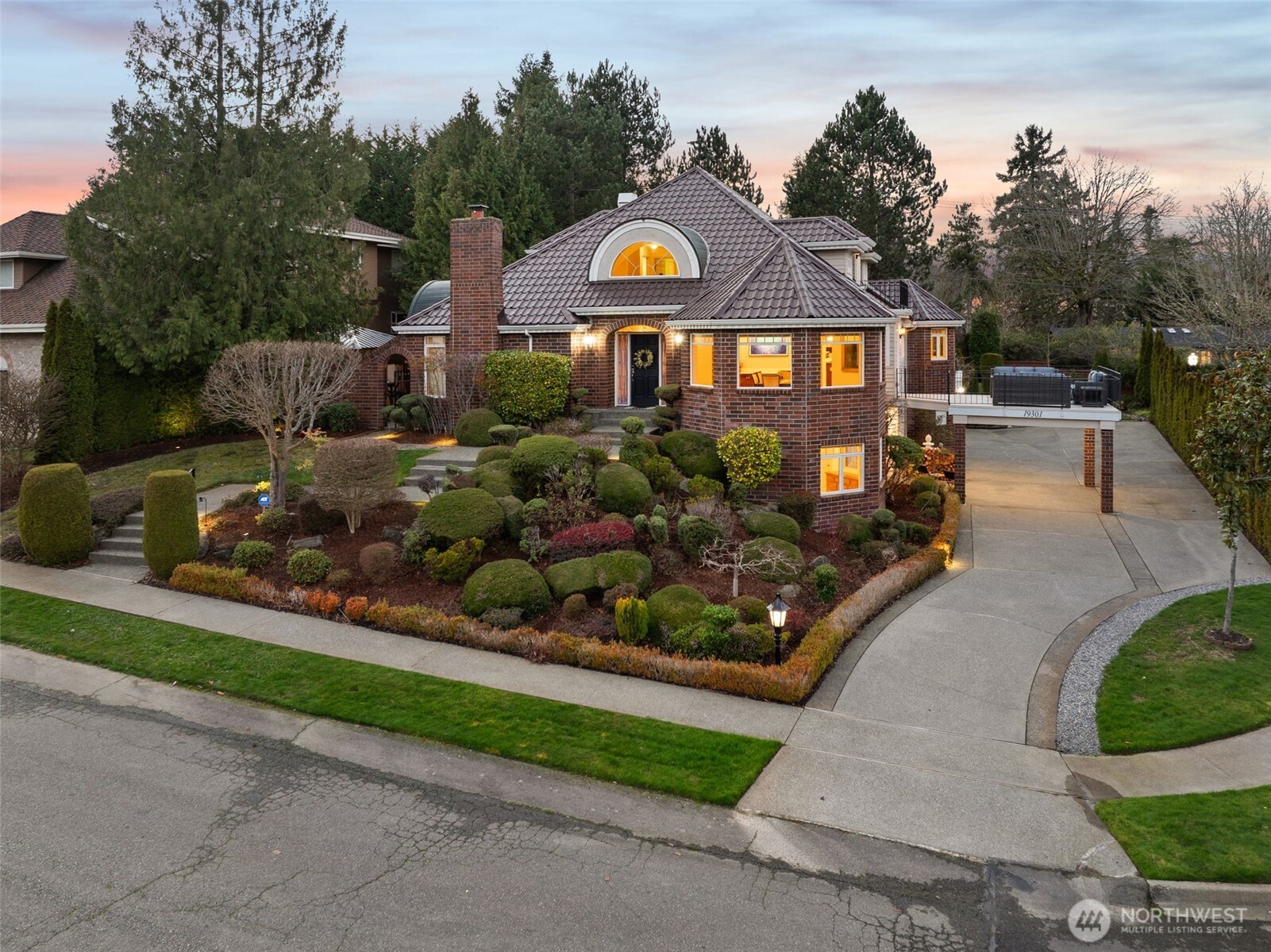 a front view of a house with a yard and potted plants