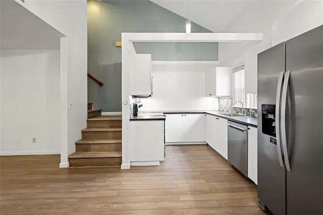 a kitchen with kitchen island white cabinets and stainless steel appliances