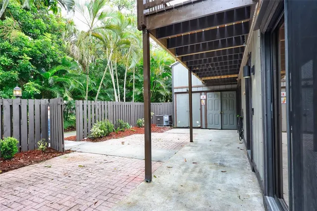 a view of small space in front of a house with wooden fence