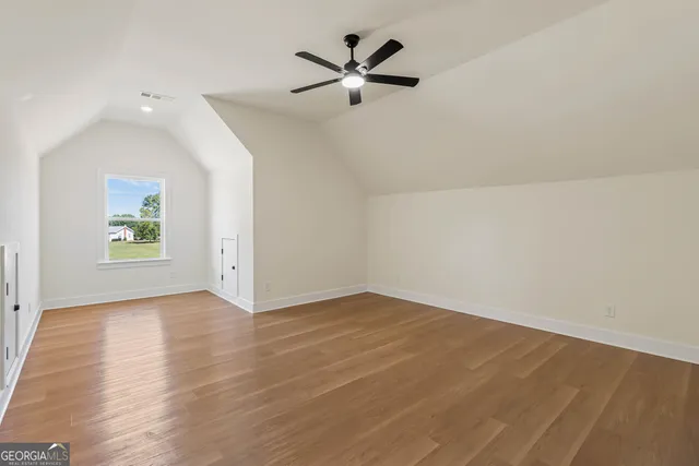 an empty room with a window and a ceiling fan