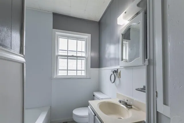 a bathroom with a toilet sink and mirror