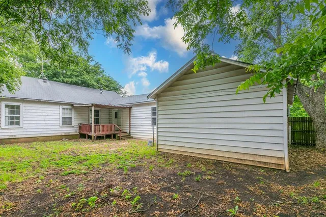 a backyard of a house with table and chairs