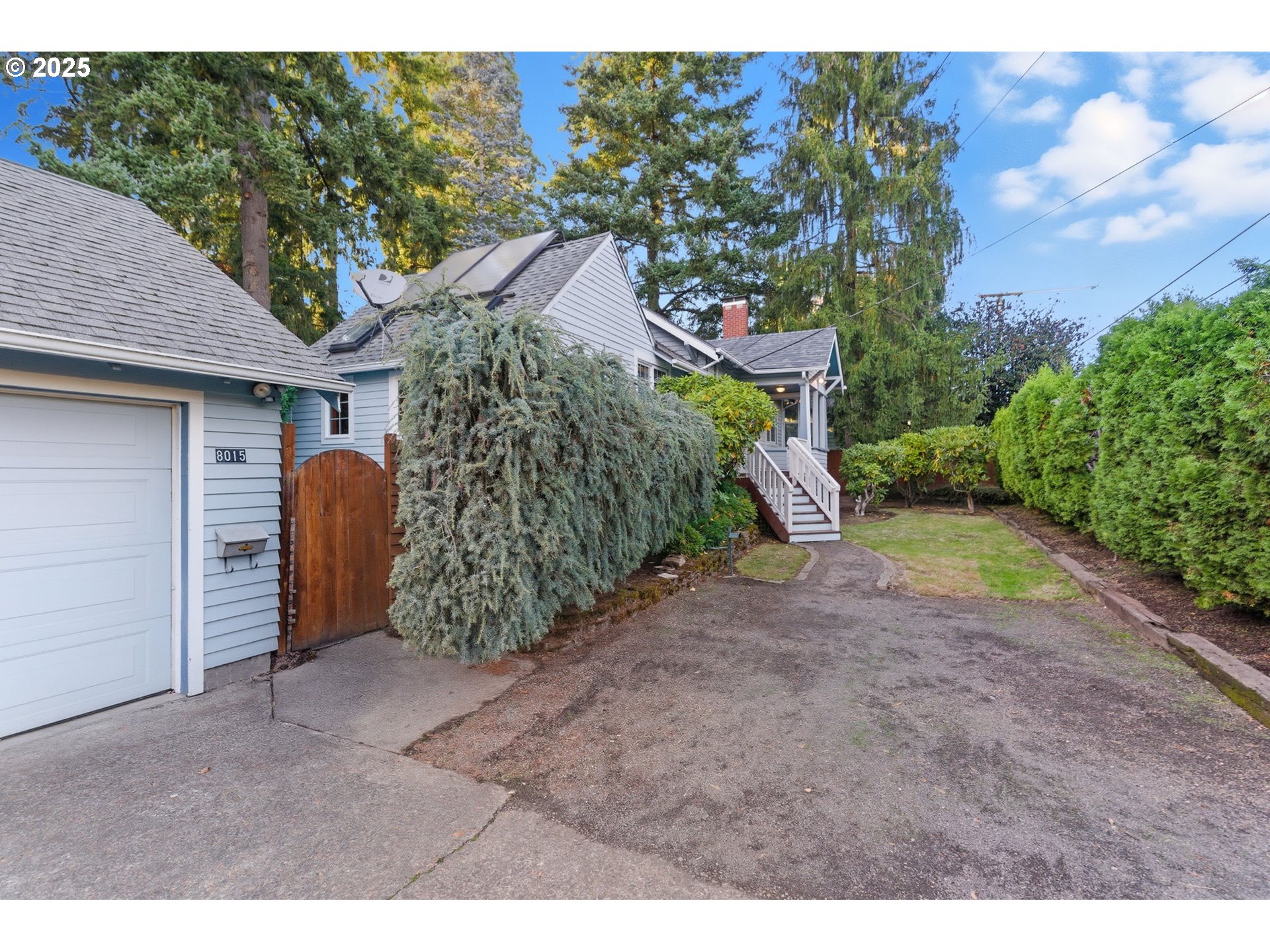 8015 Southwest 45th Avenue Portland, OR 97219 - Photo 4 of 38 a view of a house with large trees and plants