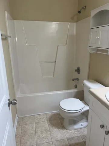a white toilet sitting next to a bath tub