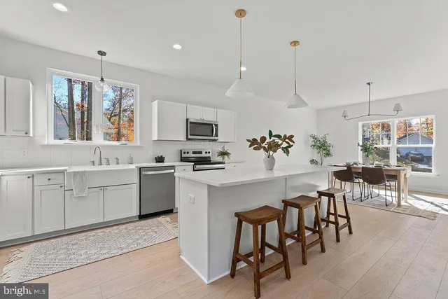 a kitchen with kitchen island white cabinets and white appliances