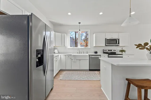 a kitchen with white cabinets and white appliances