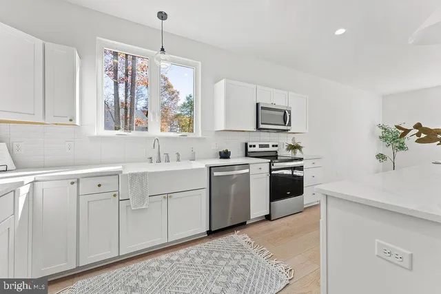 a kitchen with white cabinets and white appliances