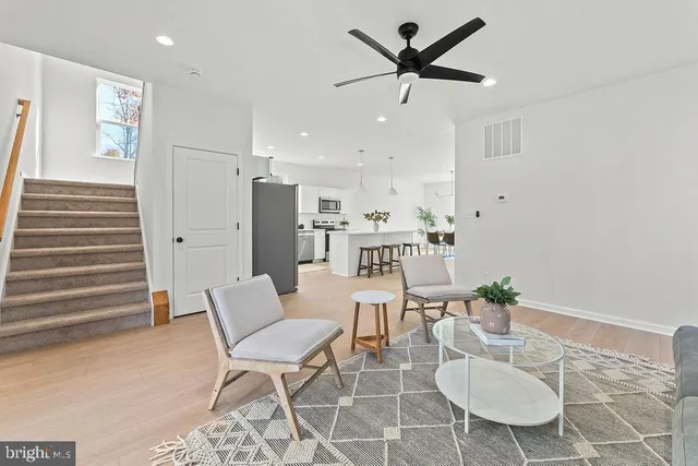 a dining room with furniture and a chandelier fan