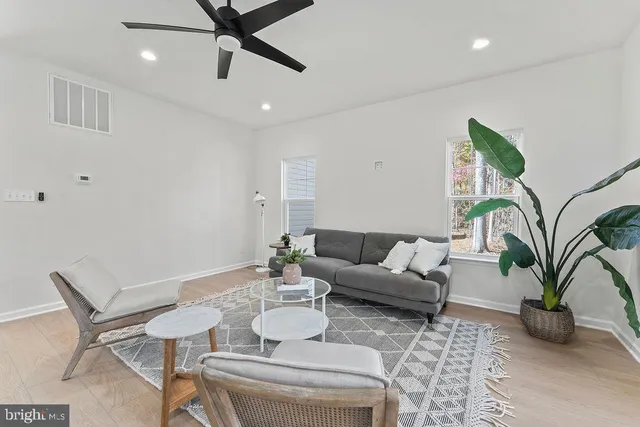 a dining room with furniture and a chandelier fan
