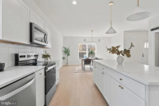 a kitchen with stainless steel appliances a sink stove and refrigerator