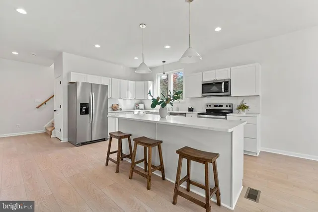 a kitchen with white cabinets and stainless steel appliances