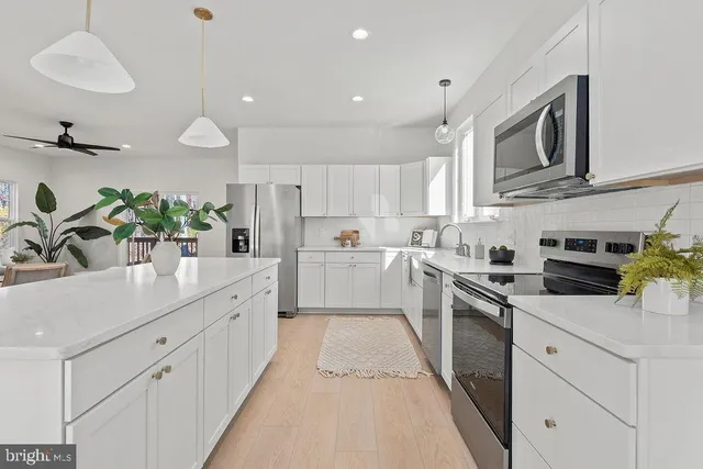 a kitchen with stainless steel appliances kitchen island granite countertop a sink a stove and cabinets
