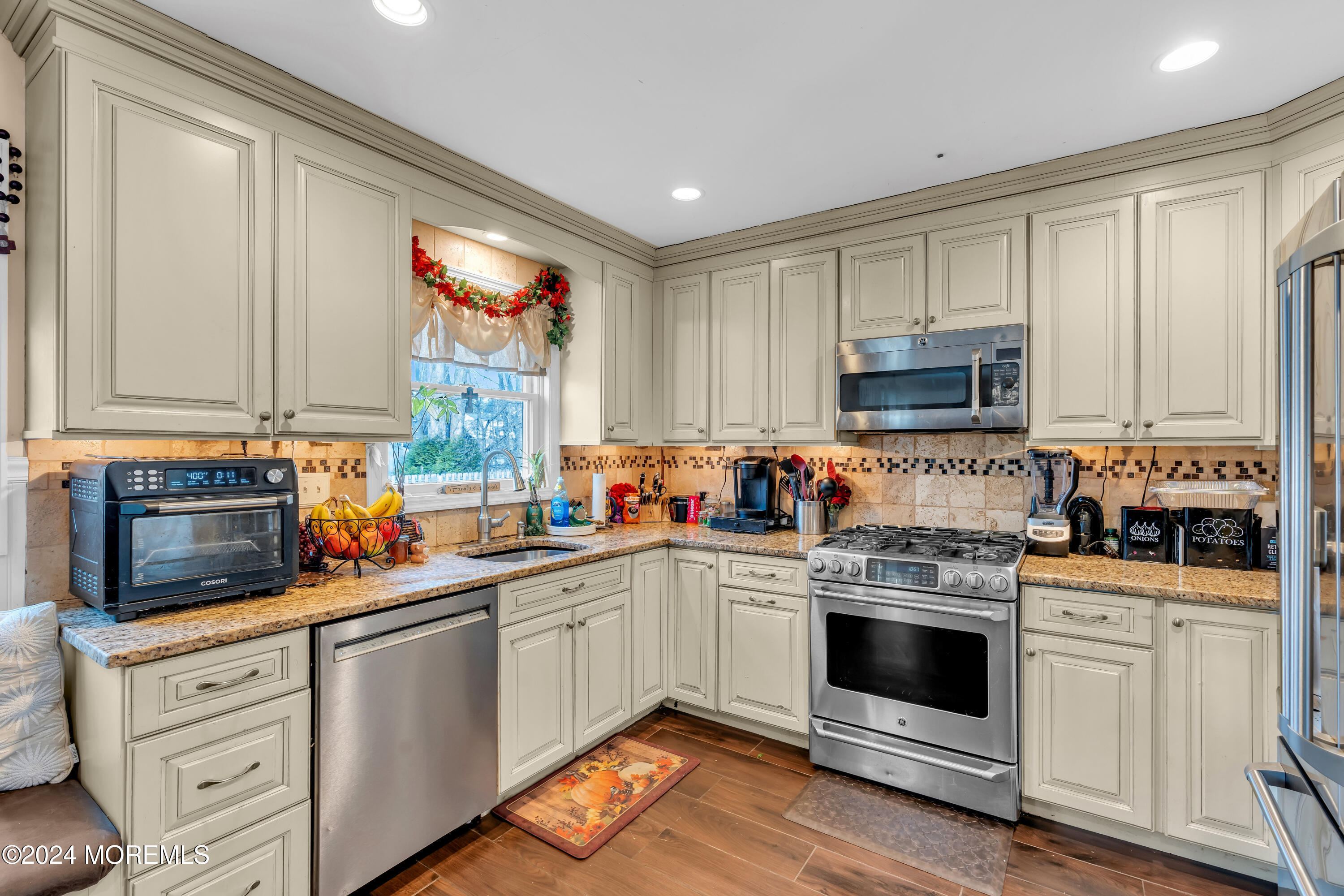 50 Hawthorne Road Middletown, NJ 07701 - Photo 12 of 33 a kitchen with white cabinets stainless steel appliances and sink