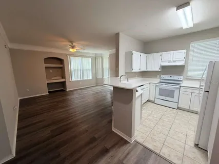 a kitchen with granite countertop a stove a sink and a refrigerator