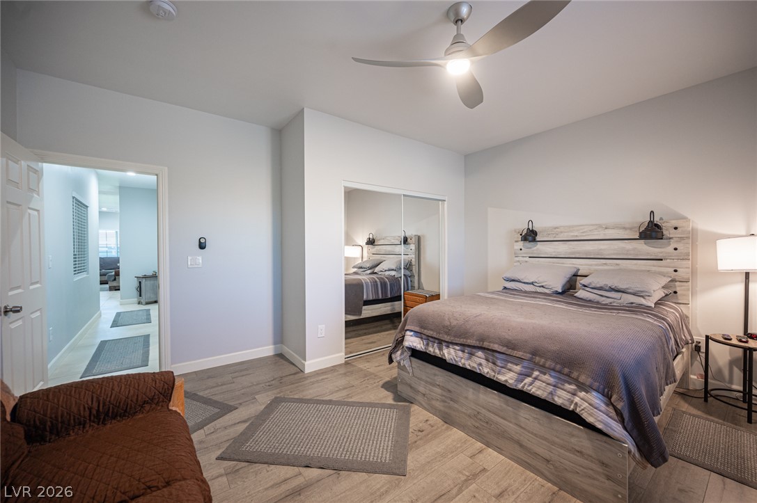 441 Belville Road Pahrump, NV 89048 - Photo 21 of 44 A well-lit bedroom features light wood-look flooring and a modern ceiling fan.