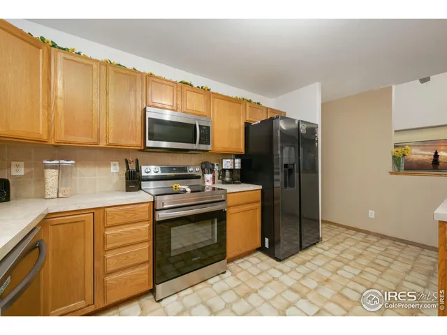 a kitchen with stainless steel appliances granite countertop a refrigerator a stove a sink and a microwave