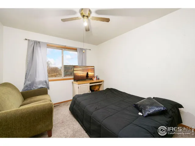 a living room with furniture ceiling fan and a window