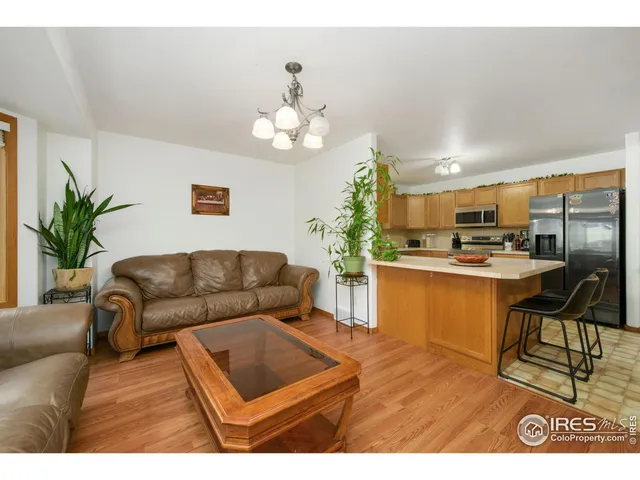 a living room with furniture kitchen view and a chandelier