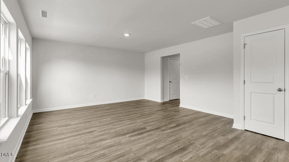 560 Stream Walk Crossing Wendell, NC 27591 - Photo 16 of 41 a view of an empty room with wooden floor and a window
