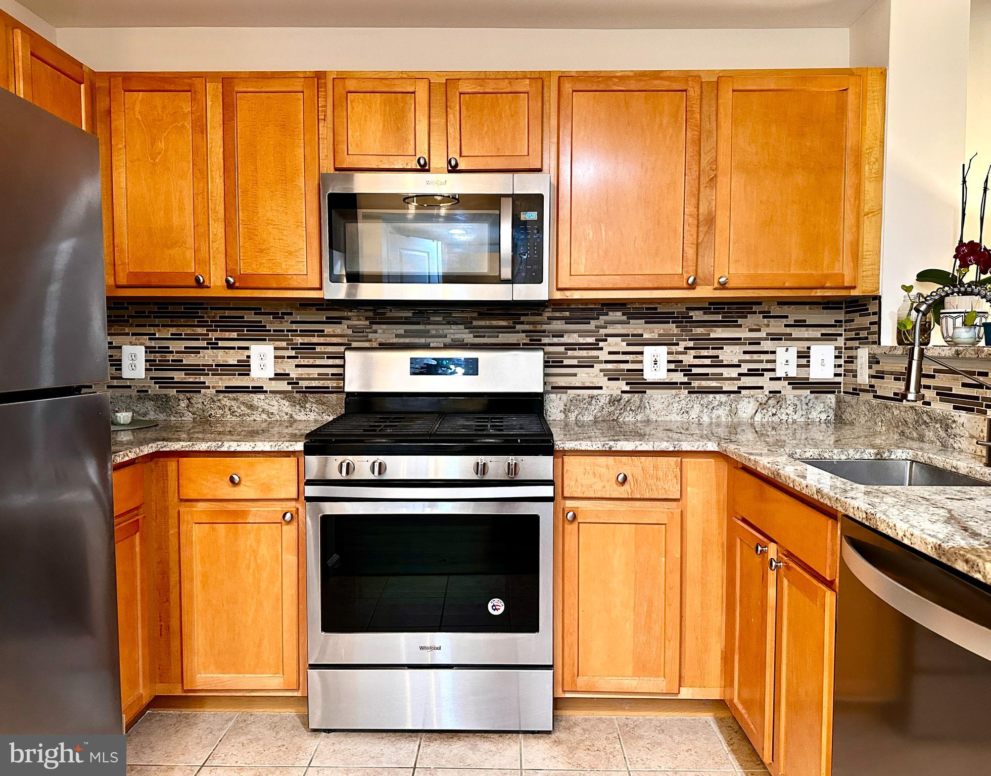 12000 Market Street, Unit 472 Reston, VA 20190 - Photo 3 of 8 a kitchen with stainless steel appliances granite countertop a stove microwave and refrigerator