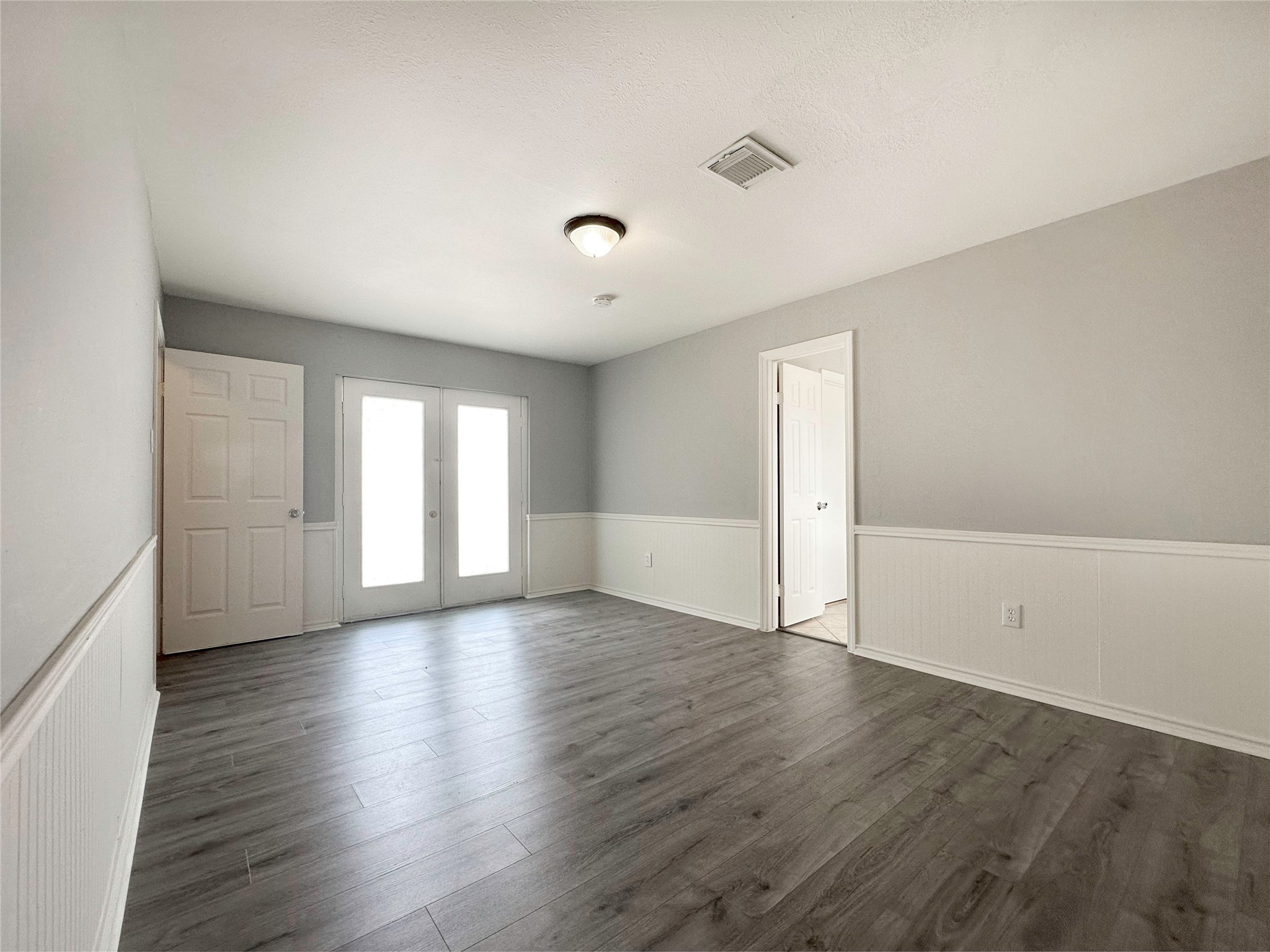 6806 Winkleman Road Houston, TX 77083 - Photo 25 of 29 an empty room with wooden floor and windows