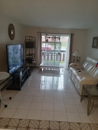 a living room with furniture and a floor to ceiling window