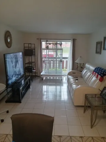 a living room with furniture and a floor to ceiling window