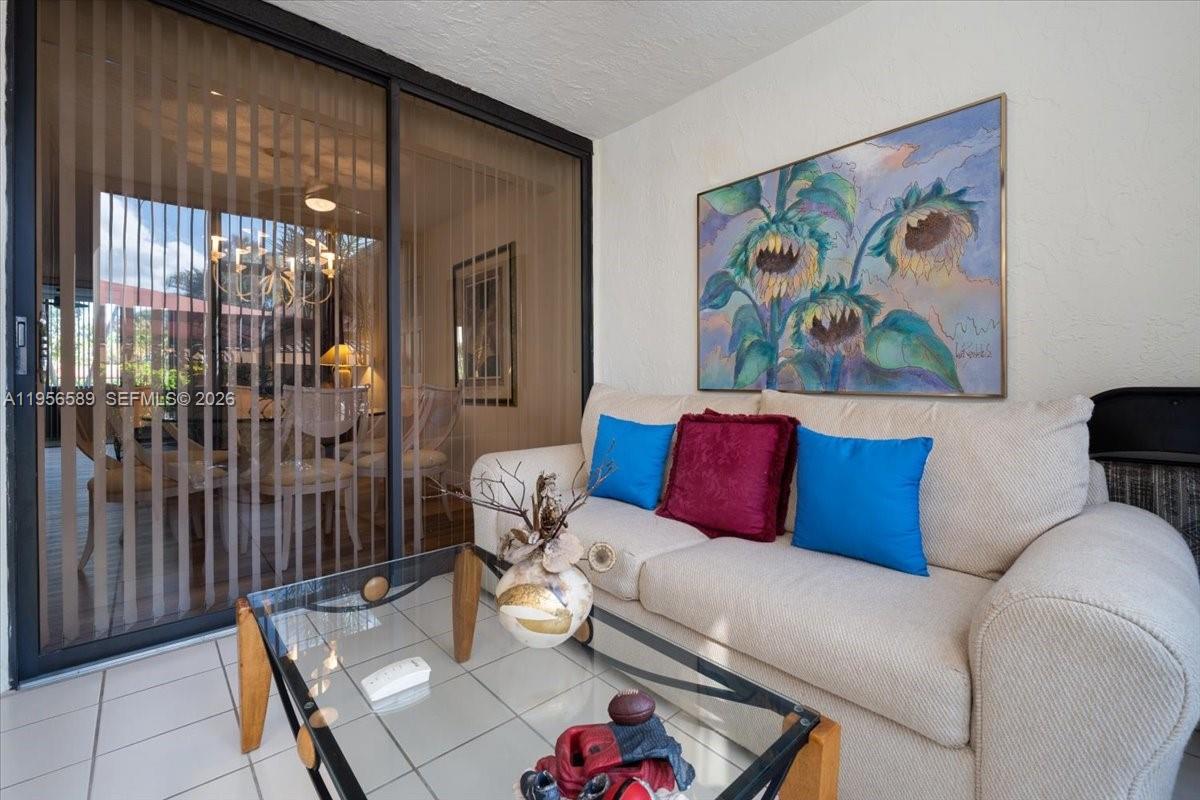 7201 Promenade Drive, Unit 101 Boca Raton, FL 33433 - Photo 11 of 54 a living room with furniture a rug and a painting on the wall