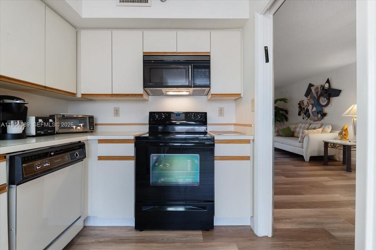 7201 Promenade Drive, Unit 101 Boca Raton, FL 33433 - Photo 19 of 54 a kitchen with stainless steel appliances kitchen island granite countertop a stove and a refrigerator