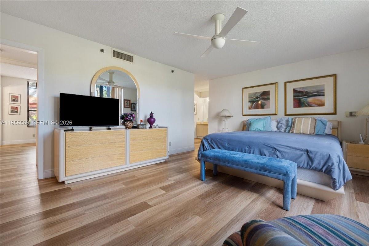 7201 Promenade Drive, Unit 101 Boca Raton, FL 33433 - Photo 24 of 54 a spacious bedroom with a bed and a flat screen tv