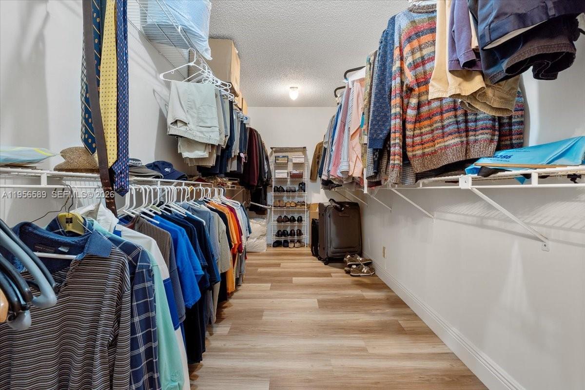7201 Promenade Drive, Unit 101 Boca Raton, FL 33433 - Photo 30 of 54 a view of walk in closet with clothes and shoes