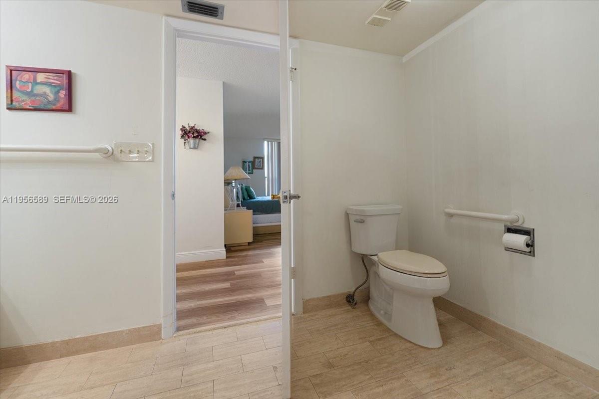 7201 Promenade Drive, Unit 101 Boca Raton, FL 33433 - Photo 33 of 54 a bathroom with a toilet and a view of bathroom