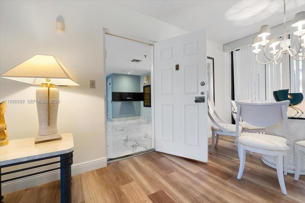7201 Promenade Drive, Unit 101 Boca Raton, FL 33433 - Photo 5 of 54 a view of kitchen with furniture and chandelier