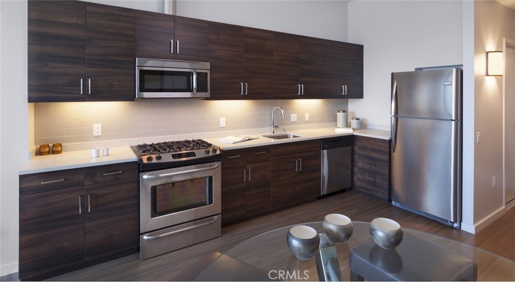100 Van Ness Avenue, Unit 2315 San Francisco, CA 94102 - Photo 4 of 75 a kitchen with stainless steel appliances granite countertop a stove a sink and a microwave
