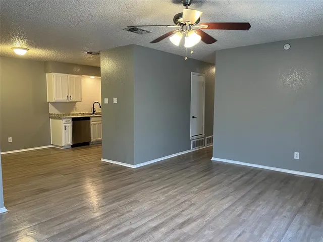 a view of a kitchen with a flat screen tv and wooden floor